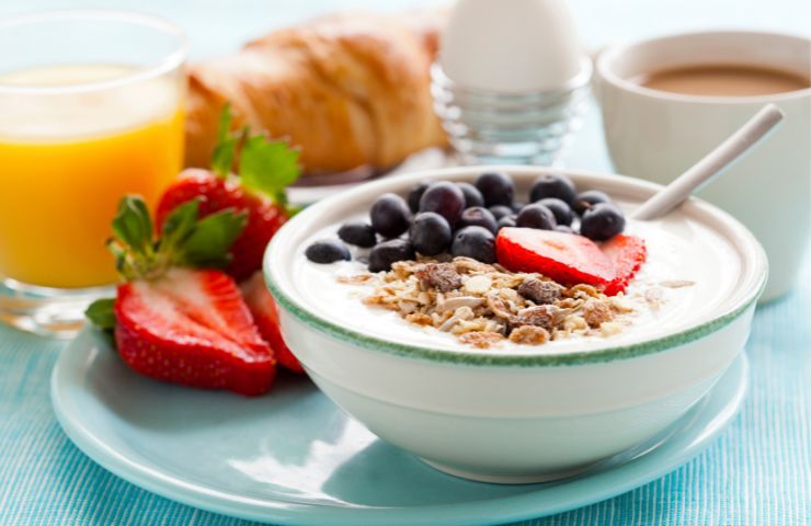 Una ciotola di latte con frutti fi bosco e cereali a colazione