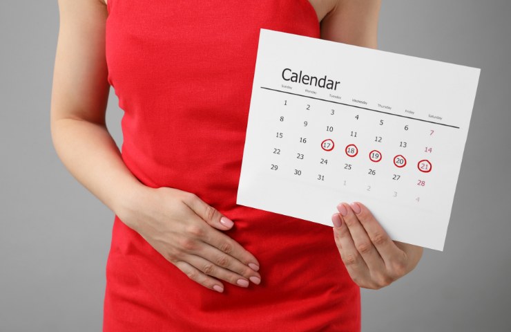Una donna con il ciclo ed un calendario in mano