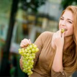 Una donna che mangia uva