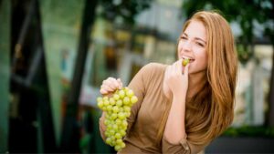 Una donna che mangia uva